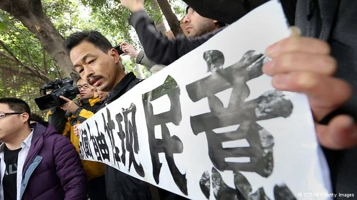 A protester calling for greater media freedom outside the headquarters of Nanfang Media Group in Guangzhou holds up a banner saying freedom of press reflects the public's opinion in Chinese on January9,2013. A Chinese weekly newspaper at the centre of rare public protests about government censorship will publish as usual on January10, a senior reporter said, following reports of a deal to end the row. The row at the popular liberal paper, which had an article urging greater rights protection replaced with one praising the ruling communist party, has seen demonstrators mass outside its headquarters in the southern city of Guangzhou. AFP PHOTO(Photo credit should read STR/AFP/Getty Images)