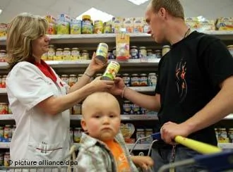 Die Mitarbeiterin Karin Jacobs vom Drogeriemarkt Rossmann in Frankfurt(Oder) berät einen Kunden mit Kleinkind beim Kauf von Babynahrung aufgenommen am23.05.2007(Illustrationsfoto zum Thema Frauen im Beruf). Foto: Patrick Pleul+++(c) dpa- Report+++