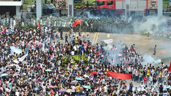 epa03399644 Riot police fire tear gas at protesters outside the city headquarters of Communist Party of China during an anti-Japan protest in Shenzhen in south China's Guangdong province16 September2012. Protests across several Chinese cities continued, in the country's ongoing row with Japan over disputed islands in the South China Sea. In the capital, Beijing, several thousand people, mostly young, carried Chinese flags and images of Mao in front of the Japanese embassy. Police were seen in heavy numbers. The demonstrators called on Japan to withdraw from the islands. The dispute between the two countries escalated on Friday when six Chinese ships began patrolling the waters around the islands. EPA/LAN QING CHINA OUT
