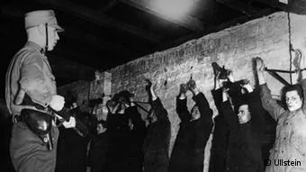 Politische Gegner der Nationalsozialisten nach ihrer Verhaftung im Keller eines SA-Sturmlokals in Berlin,1933, mit erhobenen und gefesselten Händen an einer Mauer stehend.
