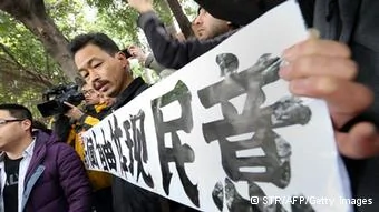 A protester calling for greater media freedom outside the headquarters of Nanfang Media Group in Guangzhou holds up a banner saying freedom of press reflects the public's opinion in Chinese on January9,2013. A Chinese weekly newspaper at the centre of rare public protests about government censorship will publish as usual on January10, a senior reporter said, following reports of a deal to end the row. The row at the popular liberal paper, which had an article urging greater rights protection replaced with one praising the ruling communist party, has seen demonstrators mass outside its headquarters in the southern city of Guangzhou. AFP PHOTO(Photo credit should read STR/AFP/Getty Images)