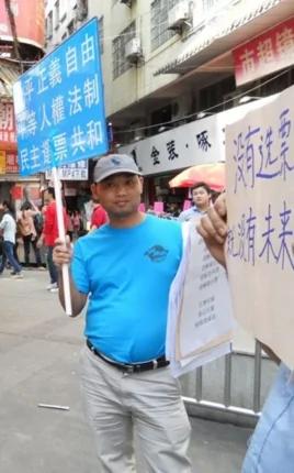 杨崇去年三月在广州街头参与公民举牌活动(微博图片)