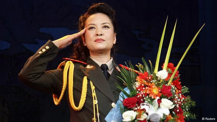 China's new first lady and singer Peng Liyuan salutes during a performance for a People's Liberation Army's unit in Luoyang, Henan province October20,2004. Peng is best known in China as a singer, and for many years was arguably better known and certainly more popular than her husband who is China's President Xi Jinping. Picture taken October20,2004. REUTERS/Stringer(CHINA- Tags: ENTERTAINMENT POLITICS) CHINA OUT. NO COMMERCIAL OR EDITORIAL SALES IN CHINA