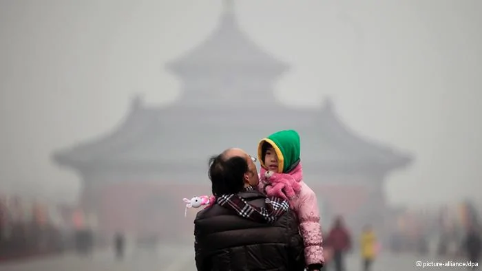 A young boy looks back while being carried by a man in front of the main hall of the'Temple of Heaven' which is barely visible due to heavy smog in Beijing, China,19 January2012. The Beijing government said it will soon release stricter air pollution limits according to reports by local media, after citizens' complaints over heavy pollution which health authorities indicate lowers life expectancy by at least five years. EPA/DIEGO AZUBEL+++(c) dpa- Bildfunk+++