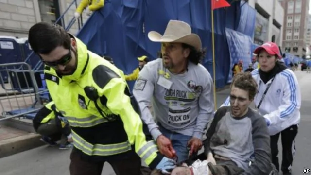 2013年4月15日，連環爆炸發生後，醫療急救人員把一名受傷男子抬過波士頓馬拉松賽的終點線。