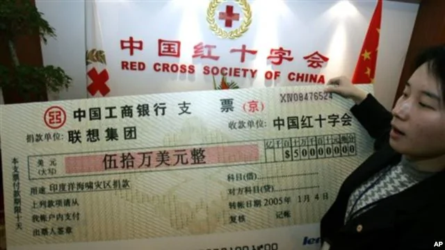 一名中國紅十字會雇員舉著中國電腦聯想集團捐助50萬美元支票的放大版本