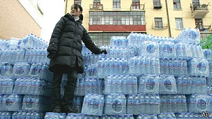黑龍江哈爾濱街頭一名女士站在一堆瓶裝水上（資料圖片）