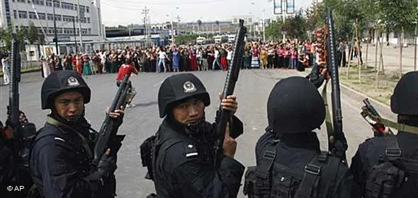 Heavily-armed special police officers face off a crowd of Uighur residents after they staged a protest in Urumqi, capital of northwest China's Xinjiang Uygur Autonomous Region, Tuesday, July7,2009. Ethnic Uighurs scuffled with armed police Tuesday in a fresh protest in the western region of Xinjiang, where at least156 people have been killed and more than1,400 people arrested in western China's worst ethnic violence in decades.(AP Photo/Ng Han Guan)
