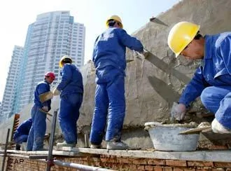 Workers build a wall in front of a new housing development in Beijing Thursday March18,2004. China's investment in fixed assets soared53 percent from a year earlier to328.7 billion yuan(US$39.8 billion) in the first two months of2004, as spending on construction surged despite official calls for restraint.(AP Photo/Greg Baker)