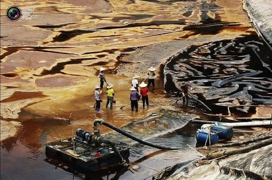 福建上杭縣的一座銅礦，工人們正給一個泄露的污水池排水。