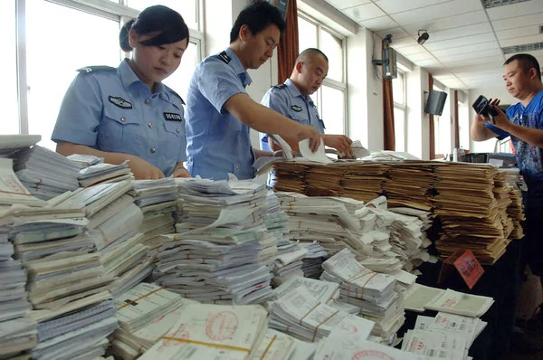 公安部的警察正在检查从北京和河北收缴的一捆捆假发票。