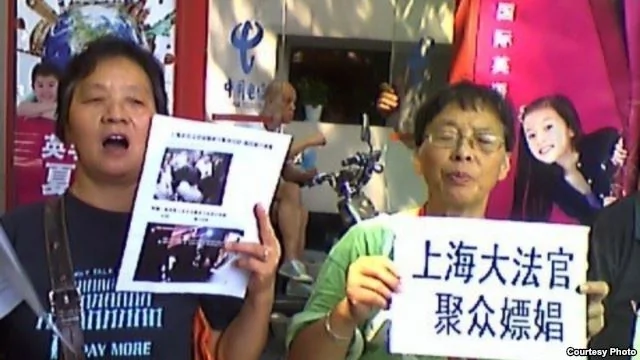上海訪民星期一在高院外舉牌抗議法官集體嫖娼和司法腐敗（圖片來源：民生觀察網）