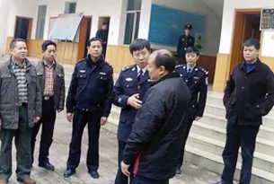 图片：李俊（前一）2010年2月底被重庆与成都检警军方人员包围“调查”。（李俊提供）