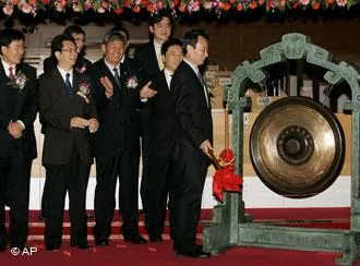 Jiang Jiemin, chiarman of PetroChina, right, hits a gong to start the day's trading at the IPO ceremony in the Shanghai Stock Exchange in Shanghai, China, Monday Nov.5,2007. PetroChina Co., the country's biggest oil and gas conglomerate, said last week it raised66.8 billion yuan($8.94 billion) from its initial public offering in Shanghai, making it China's largest domestic IPO so far. The company's shares are due to begin trading in Shanghai on Nov.5.(AP Photo/Eugene Hoshiko)