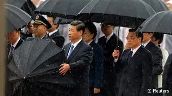 China's President Xi Jinping takes down his umbrella next to Premier Li Keqiang(R) before they and other Chinese Communist Party top leaders stand in silent tribute as it rains during a tribute ceremony at the Monument to the People's Heroes, on the64th anniversary of the founding of the People's Republic of China, in Beijing October1,2013. China celebrates its National Day on Tuesday. REUTERS/Jason Lee(CHINA- Tags: POLITICS ANNIVERSARY)