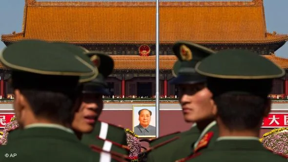Paramilitary policemen look back while patrolling on the Tiananmen Sqaure in front of the late communist leader Mao Zedong's portrait in Beijing, China, Friday, Oct.15,2010. Chinese Communist Party Central Committee meetings open Friday in Beijing, which is expected to approve the economic blueprint for2011-2015 that will promote policies to close yawning gaps between rich and poor and to encourage consumer spending as a new economic driver.(AP Photo/Alexander F. Yuan)