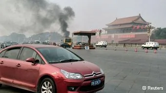 Vehicles travel along Chang'an Avenue as smoke raises in front of a portrait of late Chinese Chairman Mao Zedong at Tiananmen Square in Beijing October28,2013. Three people were killed and many injured on Monday, police said, when a car ploughed into pedestrians and caught fire in Beijing's Tiananmen Square, the site of1989 pro-democracy protests bloodily suppressed by the government. REUTERS/Staff(CHINA- Tags: DISASTER POLITICS SOCIETY TPX IMAGES OF THE DAY) CHINA OUT. NO COMMERCIAL OR EDITORIAL SALES IN CHINA