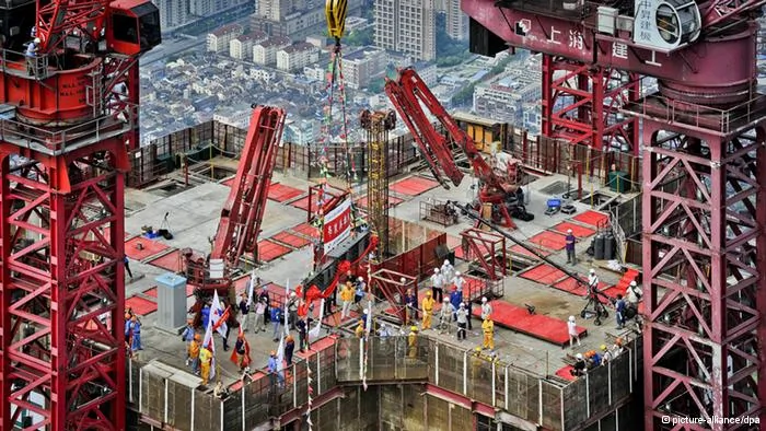 ARCHIV- Arbeiter bringen am03.08.2013 in Shanghai den letzten Stahlträger des632-Meter hohen Shanghai Towers in Position. Am Freitag(18.10.2013) werden in Peking Zahlen vorgestellt, die Chinas Wirtschaftswachstum im dritten Quartal beziffern sollen. Foto: An Tu/epa/dpa(zu dpa-meldung vom18.10.2013)+++(c) dpa- Bildfunk+++
