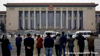 People watch as police officers check visitors in front of the Great Hall of the People during a gathering of the205-member Central Committee's third annual plenum in Beijing, China Saturday, Nov.9,2013. Reform advocates are looking to China's leaders to launch a new era of change by giving entrepreneurs a bigger role in the state-dominated economy and farmers more control over land at a policymaking conference that opened Saturday.(AP Photo/Andy Wong)