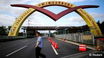 A man walks past a welcoming sign of the newly announced Shanghai Free Trade Zone in Shanghai in this September25,2013 file photo. China's leaders will lay out plans to transform the world's second-largest economy at a key party meeting in November, leaving the question of how to do it largely unanswered as much of the reform agenda is still a matter of heated internal debate. To match CHINA-ECONOMY/REFORMS REUTERS/Carlos Barria/Files(CHINA- Tags: POLITICS BUSINESS)