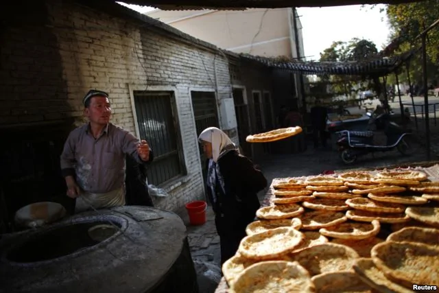 新疆维族人在集市上烤面饼