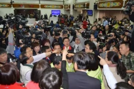 2014年3月12日，台灣立法院有關服貿協議審議還沒開始，就圍繞程序問題相互嗆聲，會場混亂。民進黨立委佔領主席台，國民黨立委抗議。（美國之音申華拍攝）