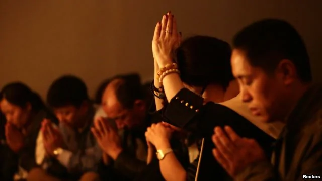 失踪马航班机乘客的亲属在北京丽都酒店祈祷。（2014年3月24日）
