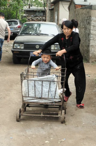 懂事的寶寶在幫外婆推垃圾車。