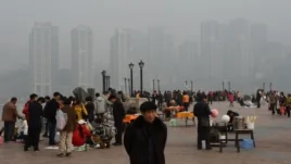 2013年2月，重慶居民在朝天門公園，背景是新建的社會保障房。薄熙來由於社會保障房等項目而在當地得人心，但也留下巨額債務