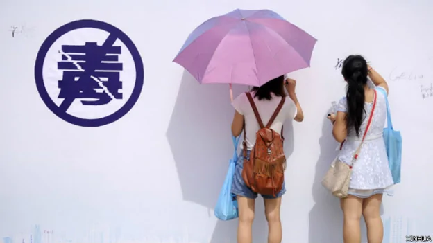 兩位女孩在廣州國際禁毒日宣傳活動的簽名牆上簽名（新華社圖片26/6/2014）