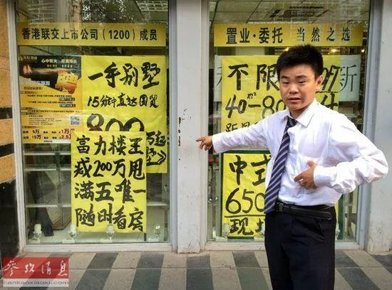 北京东三环一小区外，一名房屋中介工作人员向过往行人推荐一套号称“减200万甩”的二手房（6月18日摄）。新华社记者罗晓光摄