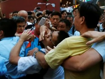 一名支持佔中者（中）被遭到反佔中者襲擊。2014年10月3日香港旺角