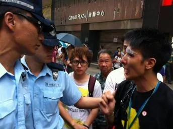 港台电视部记者(右一)被打至眼部流血。2014年10月3日。