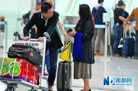 深圳机场航站楼安检大厅外，装扮时尚的女子拖着行李箱向男乘客打招呼说要改签机票，钱不够，请帮忙。