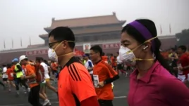 2014年北京國際馬拉松賽的參加者戴口罩在霧霾中跑步（2014年10月19日）