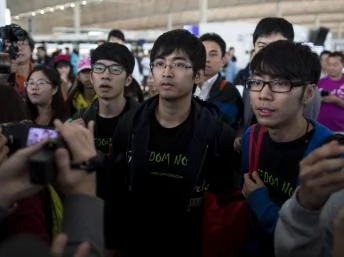 香港學生領袖11月15日欲北上遭遇沒收回鄉證，中間站立著為周永康。