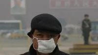 一名男子戴着口罩站在天安门广场