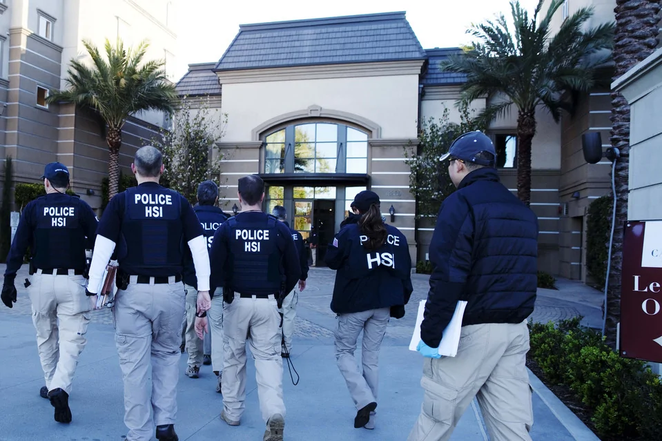 Agents from multiple agencies enter an apartment building in Irvine, Calif., on Tuesday, as part of a continuing investigation targeting birth tourism.
