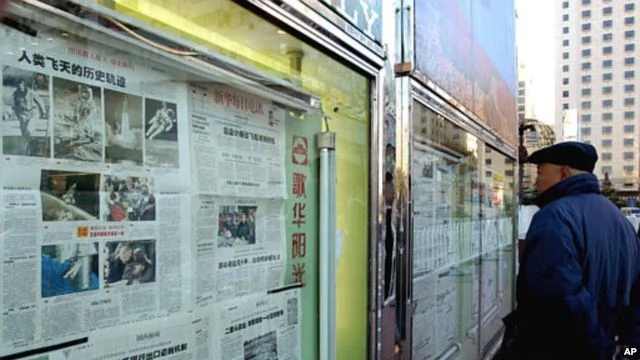 有人在北京街头看报纸（2003年）。中国报纸很多