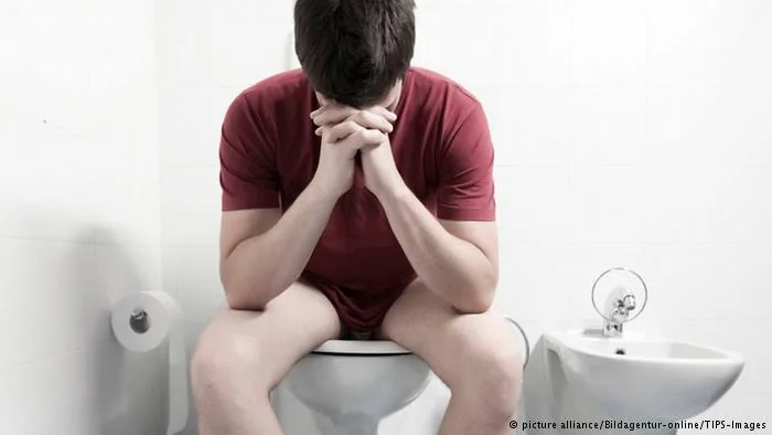 Mann sitzt auf der Toilette(Symbolbild)