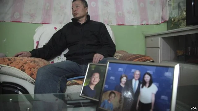 中国著名维权律师高智晟2015年在陕西的窑洞住宅里听记者讲话，旁边是他儿子的照片和女儿与美国前总统布什的合影