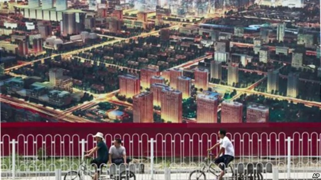 人們騎自行車經過北京一座廣告牌，廣告牌顯示了北京中央商務區的景象(資料照片)