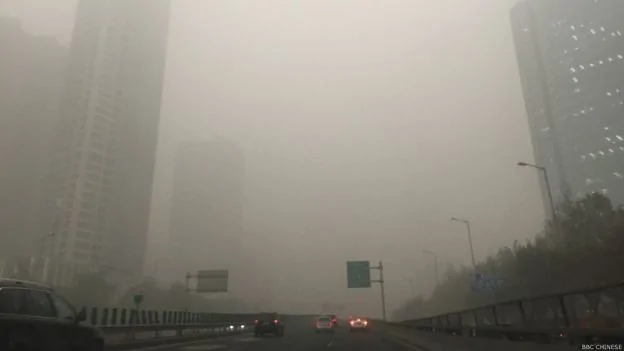 在霧霾中無法見到北京高樓的全貌。