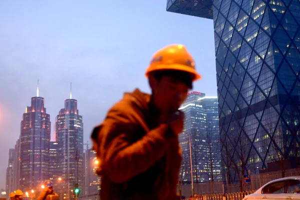 北京的一名工人。中國外匯儲備下降削弱了該國對人民幣價值的控制力。