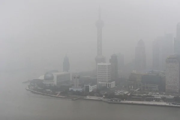 上海坊间传闻江泽民两个儿子已经被内控，上海2016年注定不太平。图为2013年1月24日，上海外滩黄浦江两岸全都笼罩在雾霾中。（CFP）