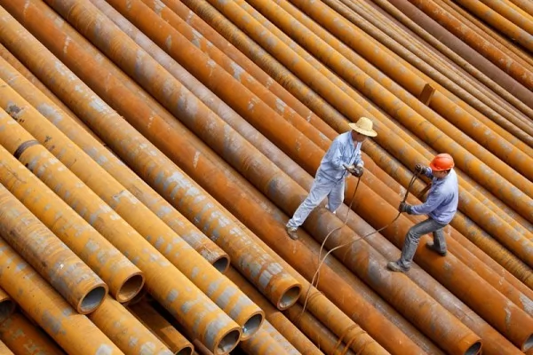 在中国东部的安徽省淮北钢铁厂工人搬运钢管。（AFP）