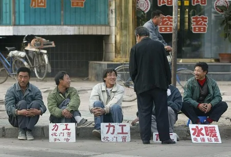 2002年10月8日遼寧的失業工人在路邊等著僱主雇他干零工。(FREDERIC J. BROWN/AFP/Getty Images)