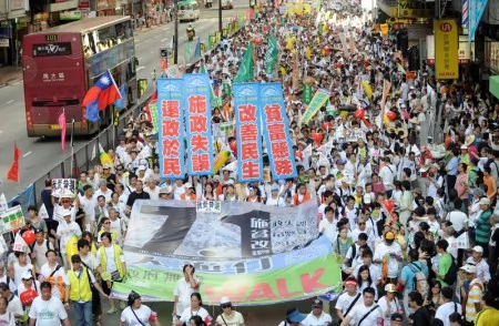2009年七一大遊行的主題為「施政失誤、貧富懸殊、還政於民、改善民生」。圖為2009年7月1日，香港，參加遊行的隊伍。（MIKE CLARKE／AFP)