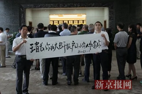 小岗村村民代表在告别厅外拉起纪念王郁昭同志的字幅。本组图片摄影：新京报记者彭子洋
