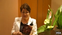 遠藤譽接受美國之音採訪時，展示早已被譯成中文的《卡子》(美國之音歌籃拍攝)